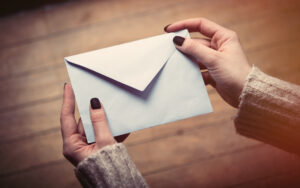 White woman holding an envelope