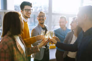 Clinking glasses with champagne. Happy coworkers celebrating their business achievement.