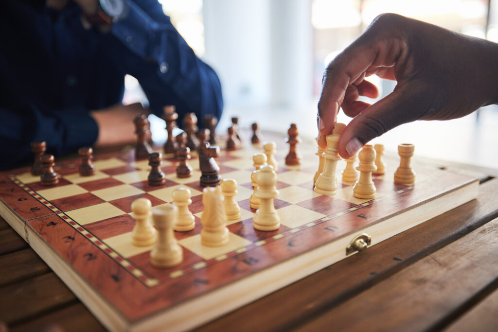 Hands, fun and people with a chess game, strategy and playing together at a competition. Table, pro.